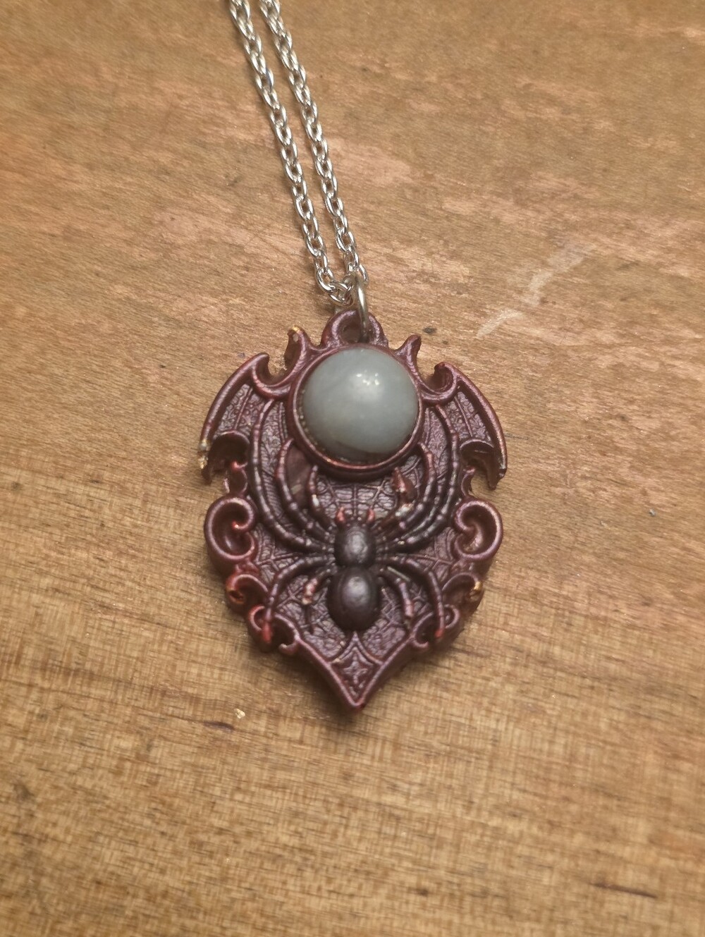 Red Spider Pendant With Central Gray Gemstone On A Silver Tone Chain Necklace